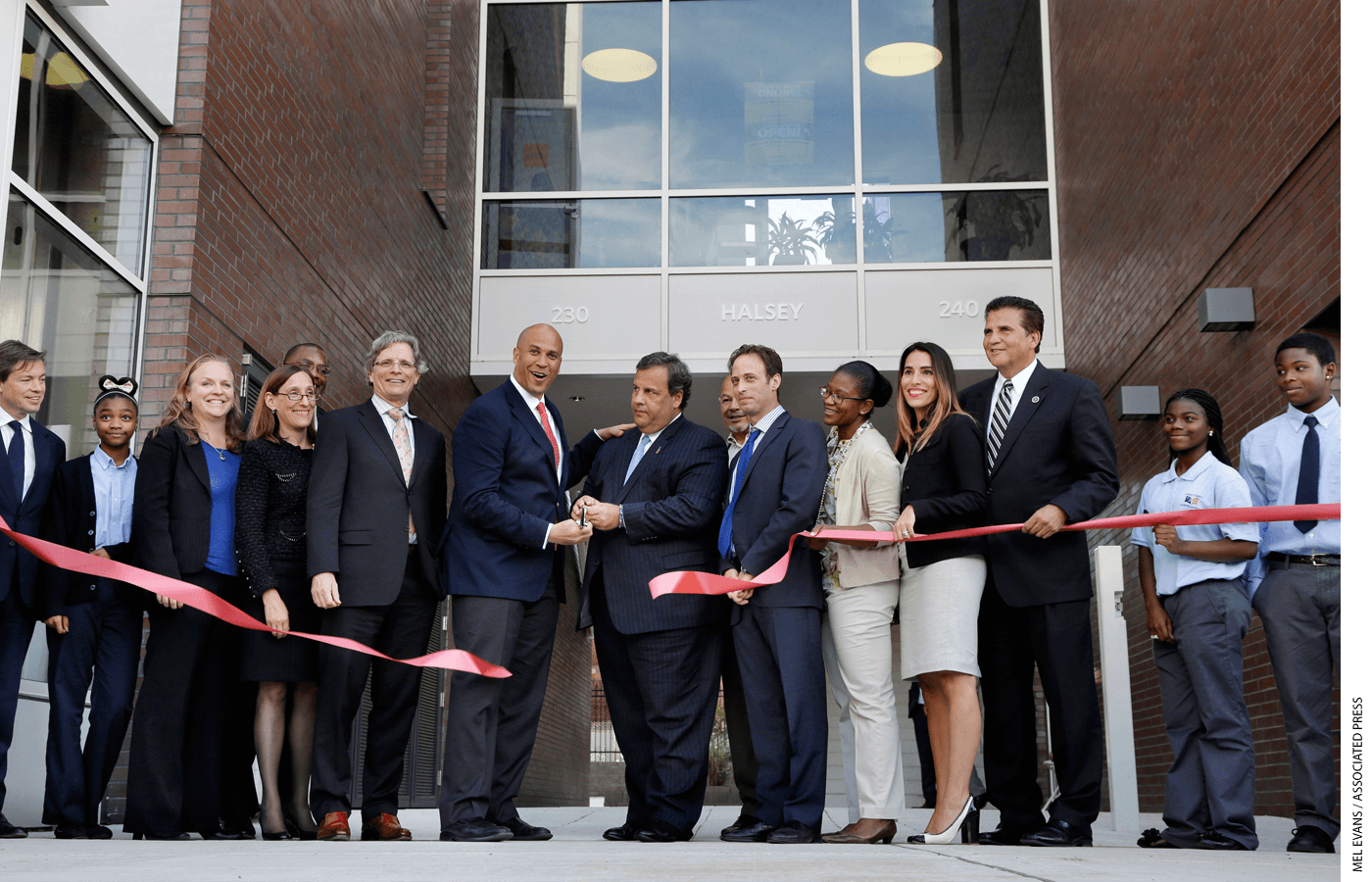 Democratic Newark Mayor and senate candidate Cory Booker, center left and Republican New Jersey Gov. Chris Christie, center right, joins others in Newark, N.J., Wednesday, Sept. 25, 2013, as they cut a ribbon during an opening ceremony for Newark charter schools.