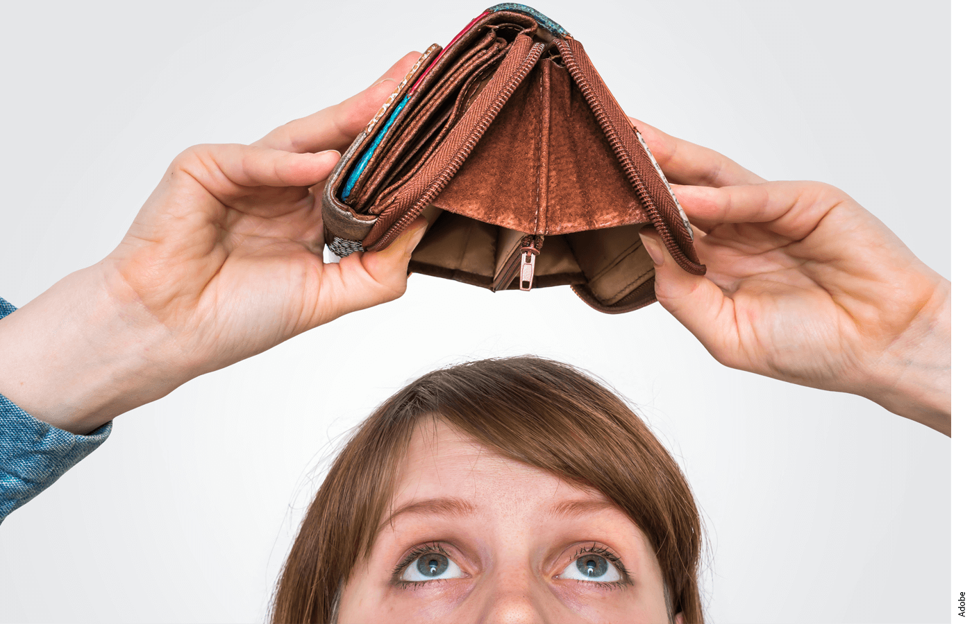 A woman holds open a wallet with no money