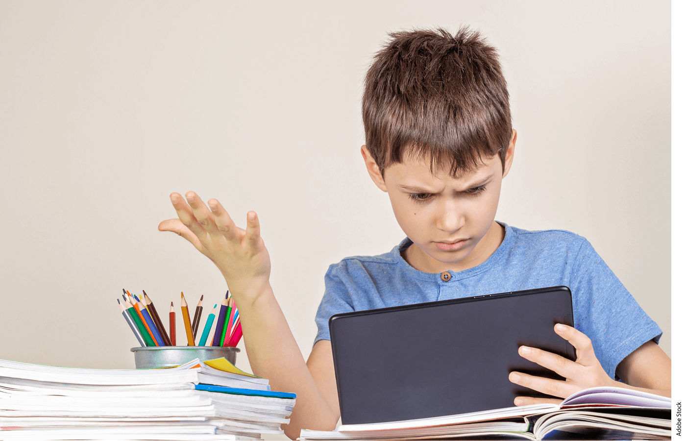 Photo of a confused student holding a tablet