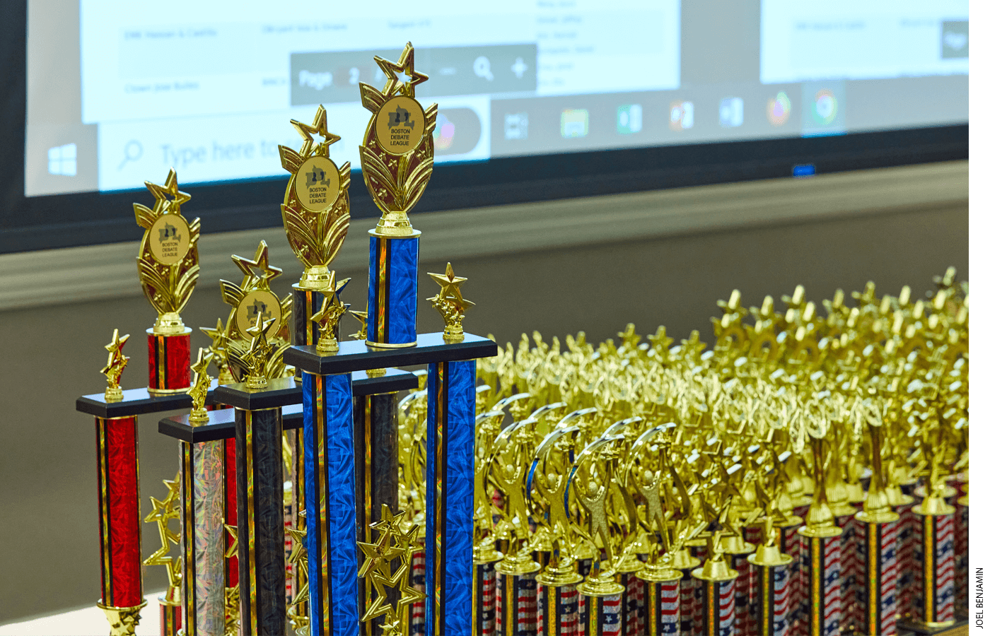 Trophies are ready for distribution at the awards ceremony for the Boston Debate League’s qualifying championship tournament. Apart from the hardware, student debaters are found to gain substantial benefits in reading achievement, graduation, and college enrollment.