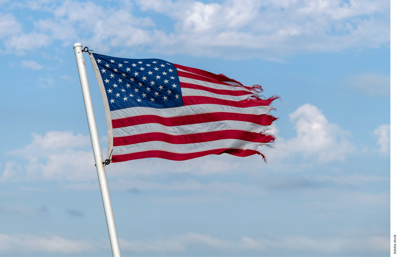 Image of an American flag on a pole with frayed ends