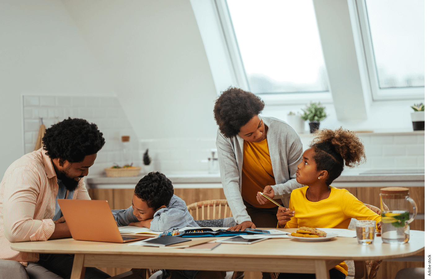 A family works on schoolwork together at a kitchen table