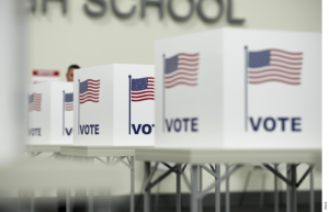 Photo of voting booths with "Vote" and the American flag printed on the side of each