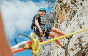 A climber is suspended by a cable on the side of a mountain