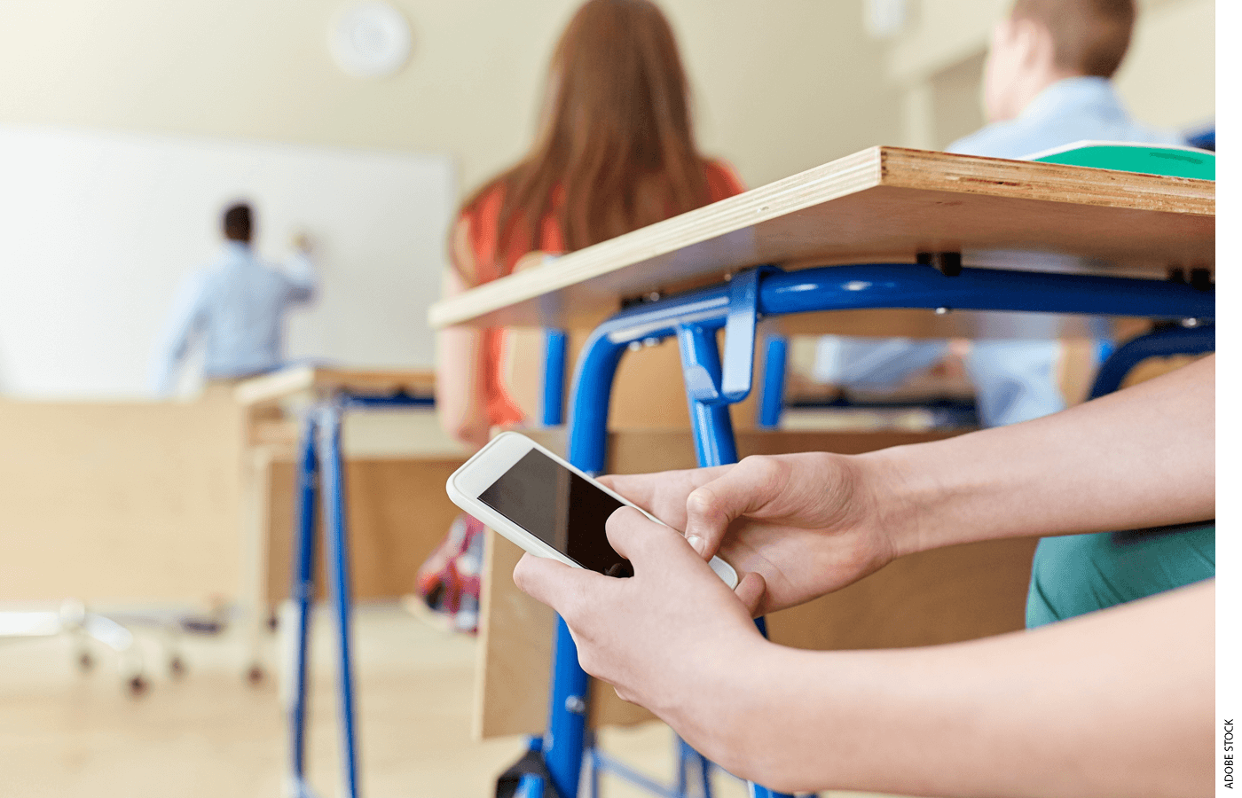 A student looks at a cellphone during class.