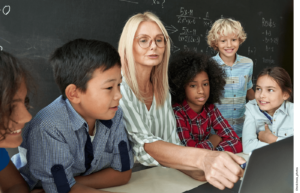 A teacher guides a lesson on a laptop while students watch