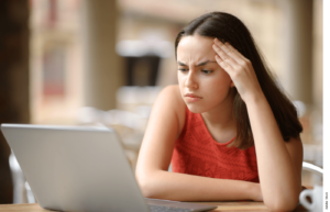 A woman looks at a laptop screen.