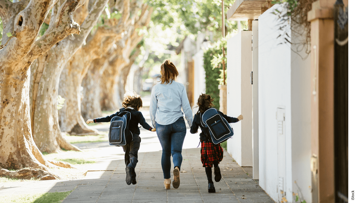 A mother walks her two children to school