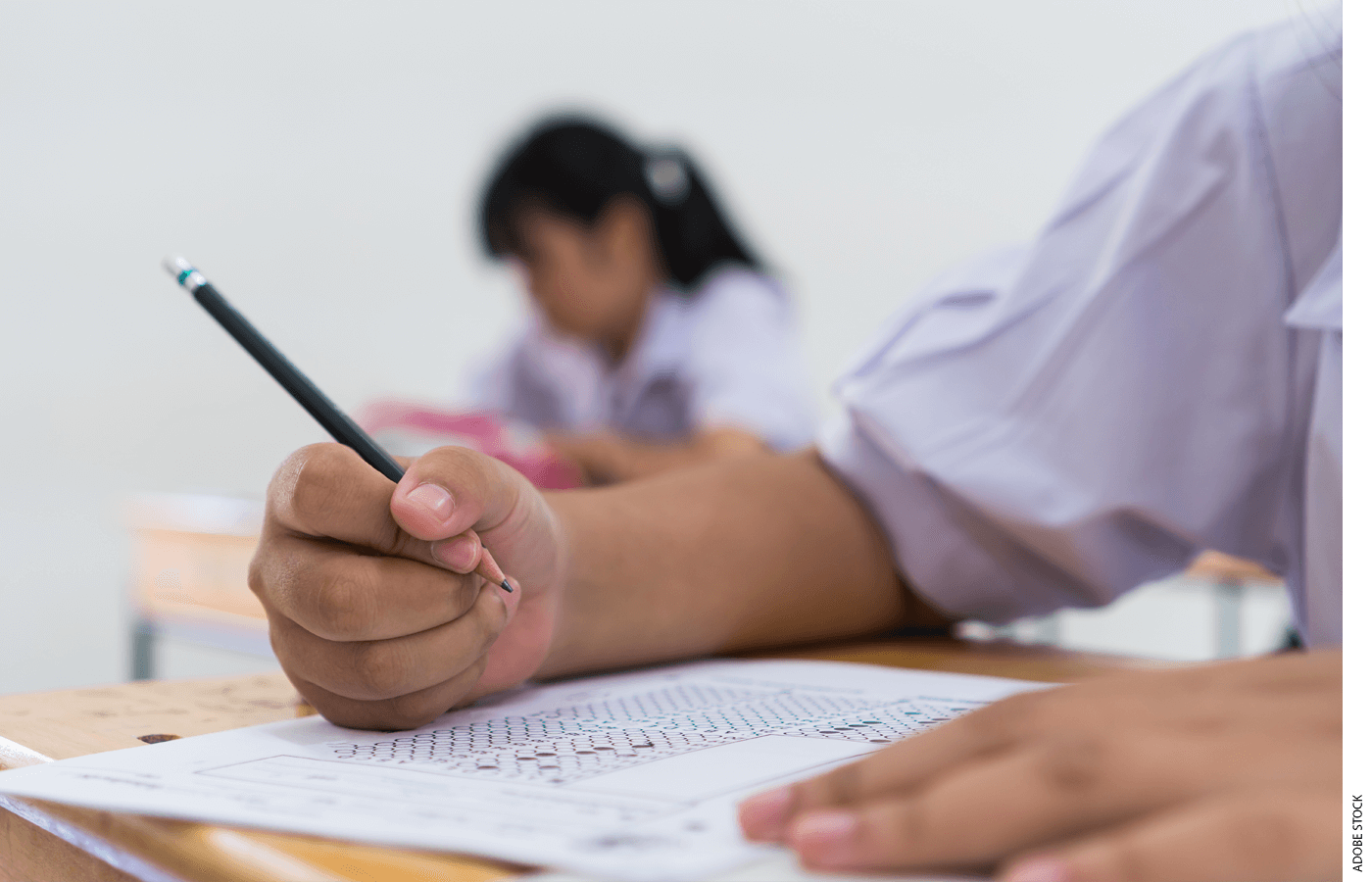 Close-up photo of a student's hand, filling out a scantron test